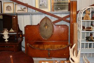 A French walnut bedstead with wicker panel and applied foliate decoration