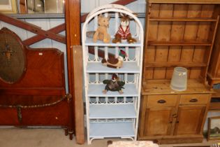 A painted wicker and bamboo shelving unit