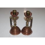 A pair of late Victorian brass and copper candlest