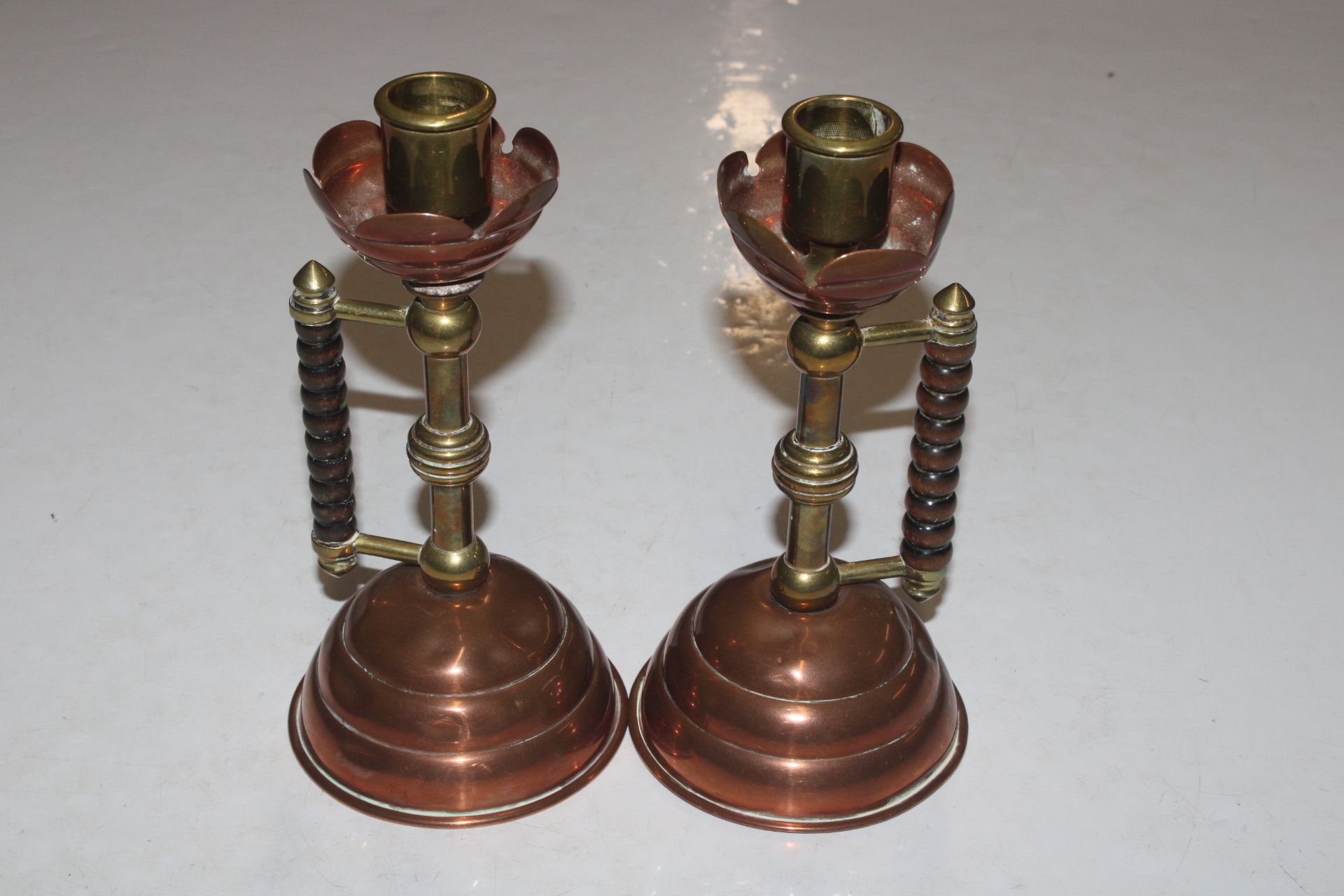 A pair of late Victorian brass and copper candlest