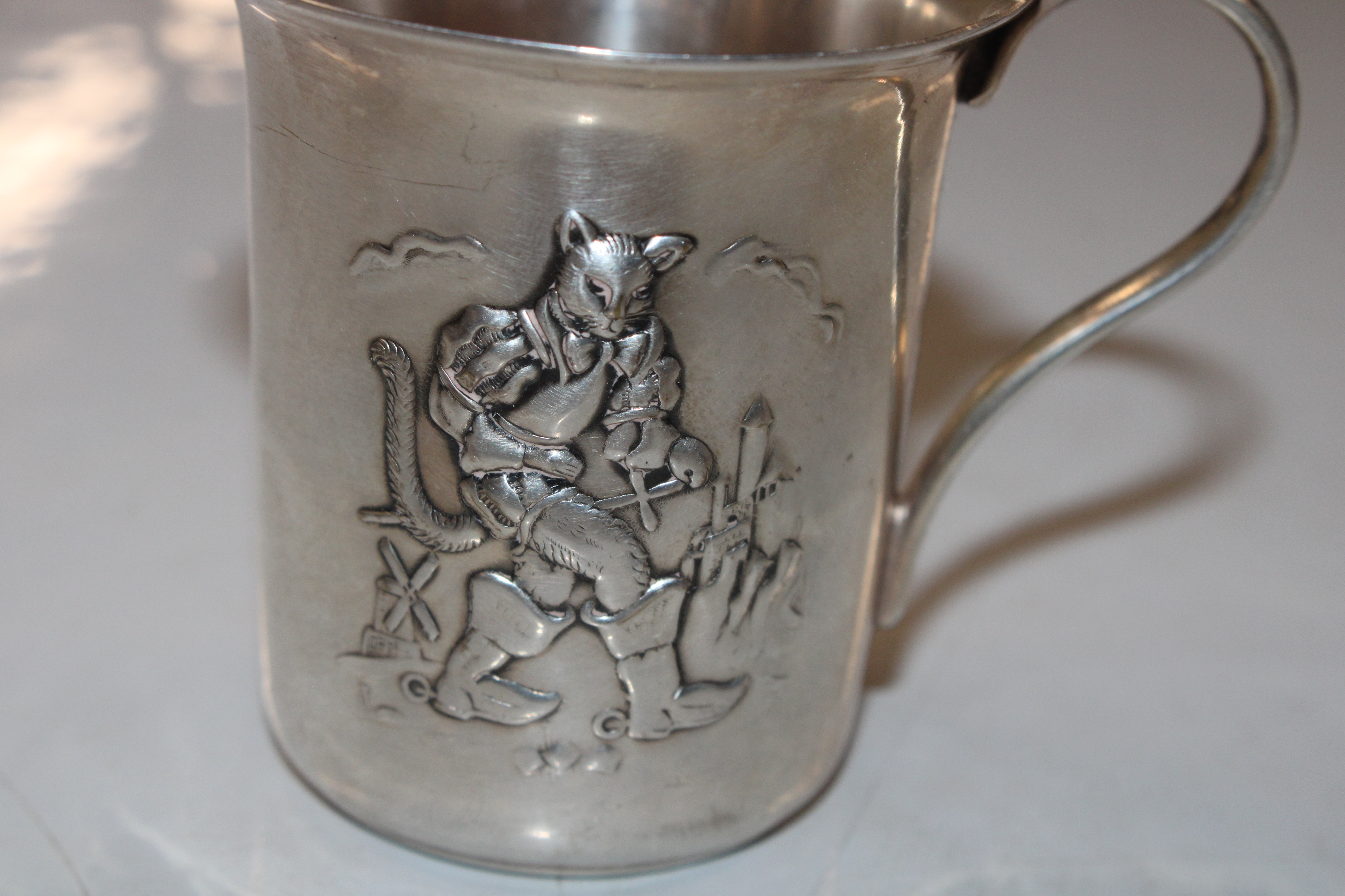 A white metal cup decorated with Puss In Boots, ap - Image 2 of 4