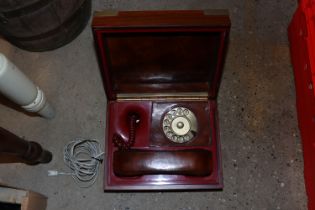 A telephone contained in a b=mahogany and brass bo