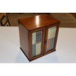 An oak cigar cabinet, the bevelled glass doors enc