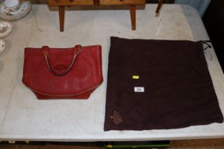 A Mulberry red handbag and outer carry bag