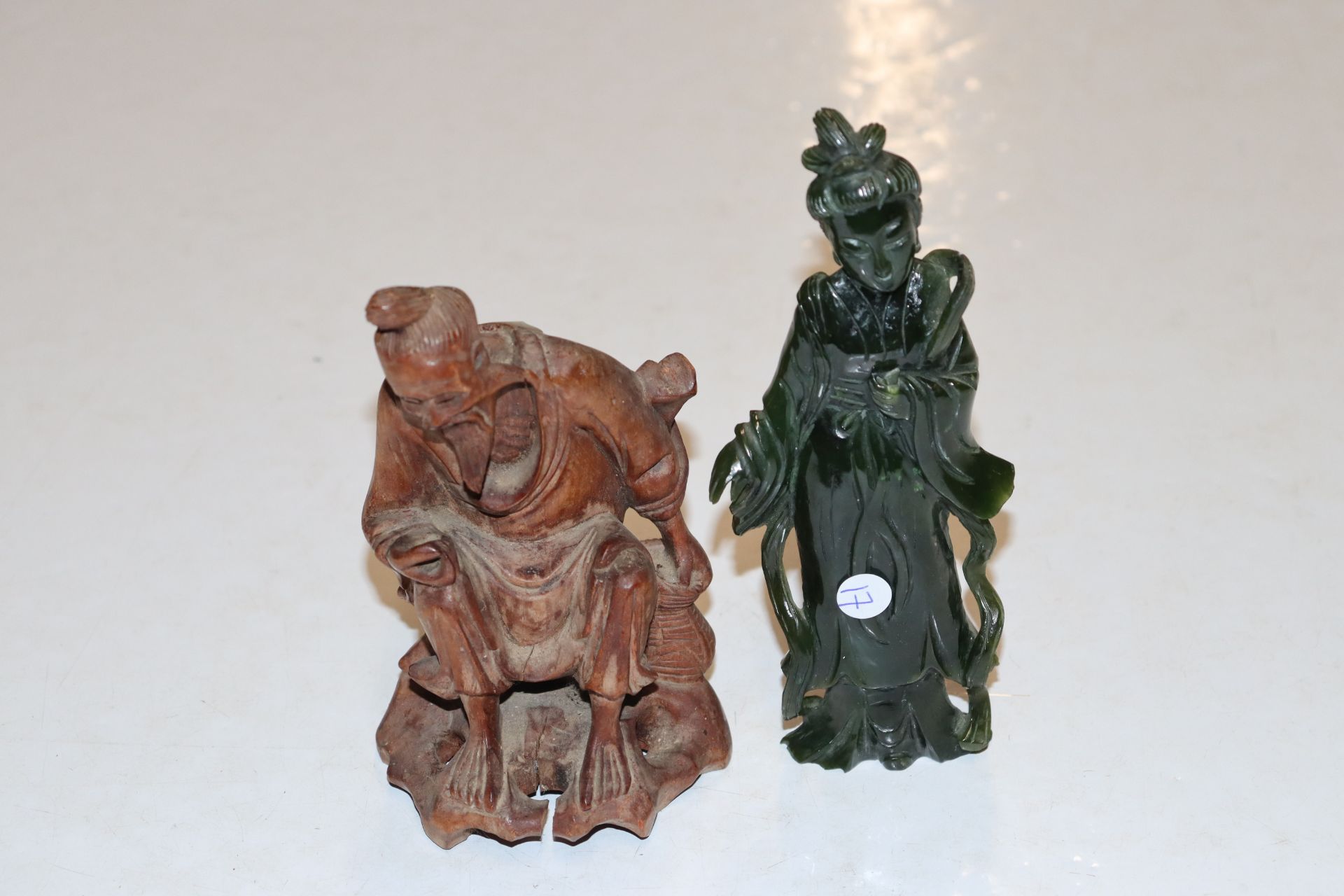 A Chinese carved dark green stone female figure an