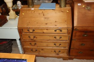 A stripped pine bureau fitted four long drawers