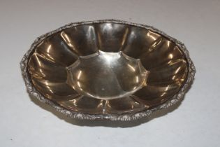 A white metal circular dish raised on four support