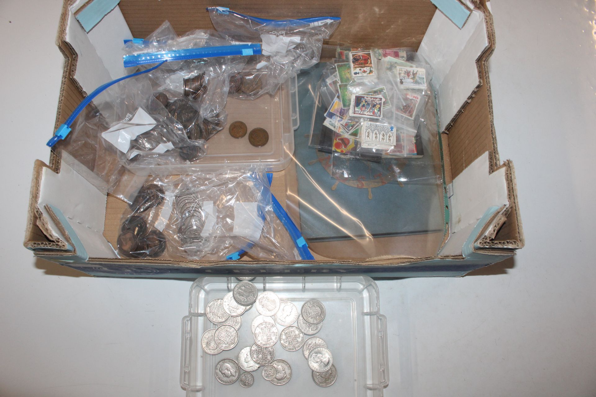 A box containing an album of stamps, various loose