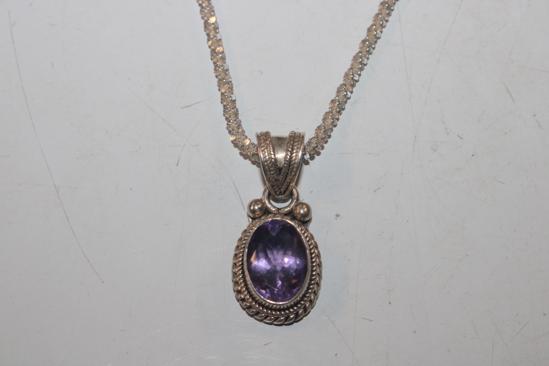 A Sterling silver and amethyst set pendant hung to