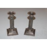 A pair of silver Corinthian column candlesticks wi