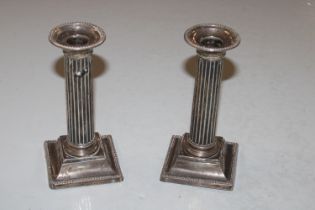 A pair of silver Corinthian column candlesticks wi