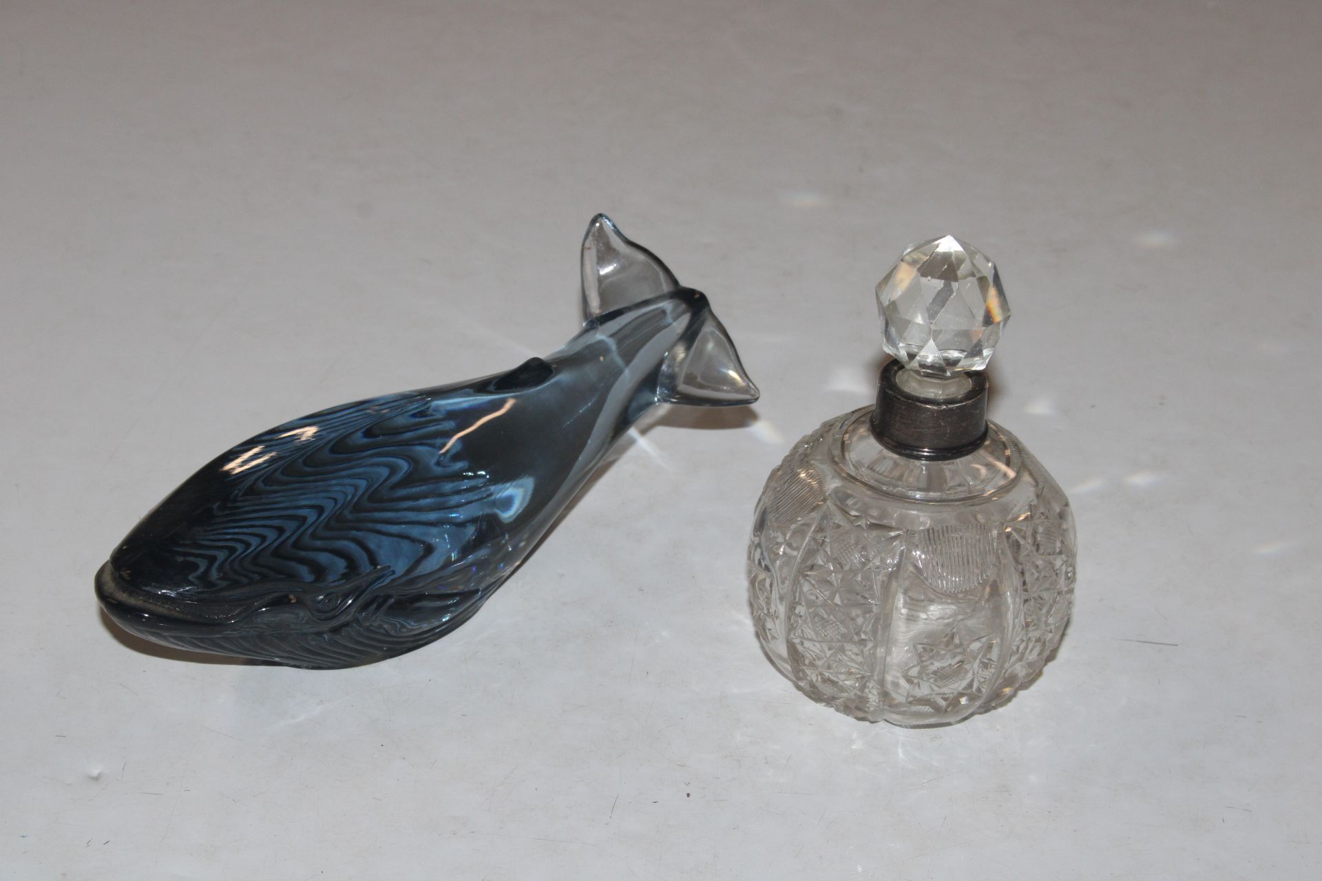 A cut glass scent bottle with white metal collar; a