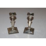 A pair of silver candlesticks with weighted bases