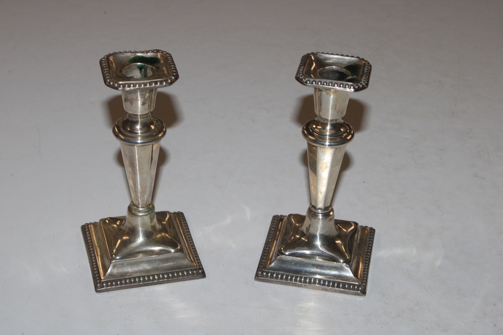 A pair of silver candlesticks with weighted bases