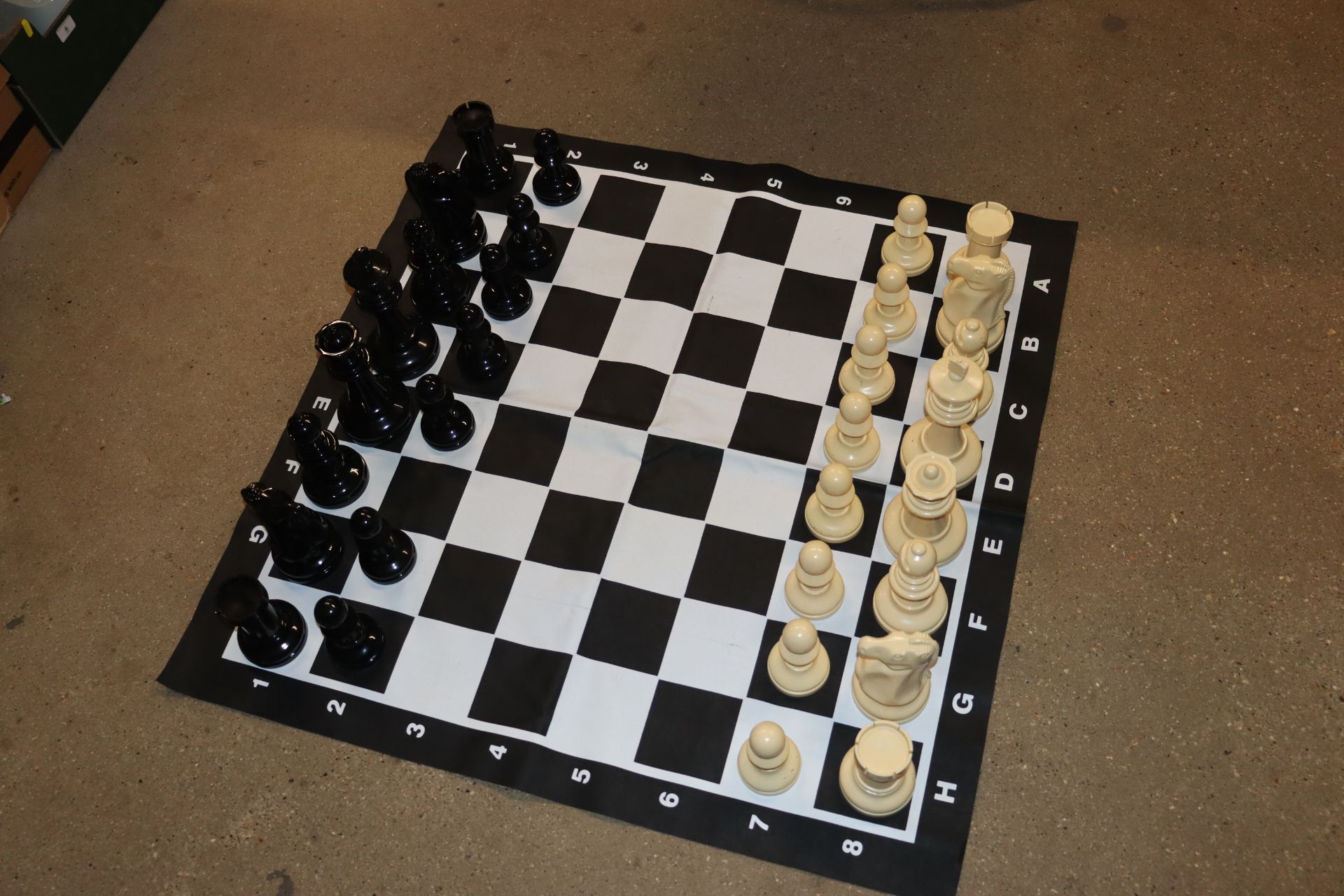 A large plastic chess set (missing one pawn)