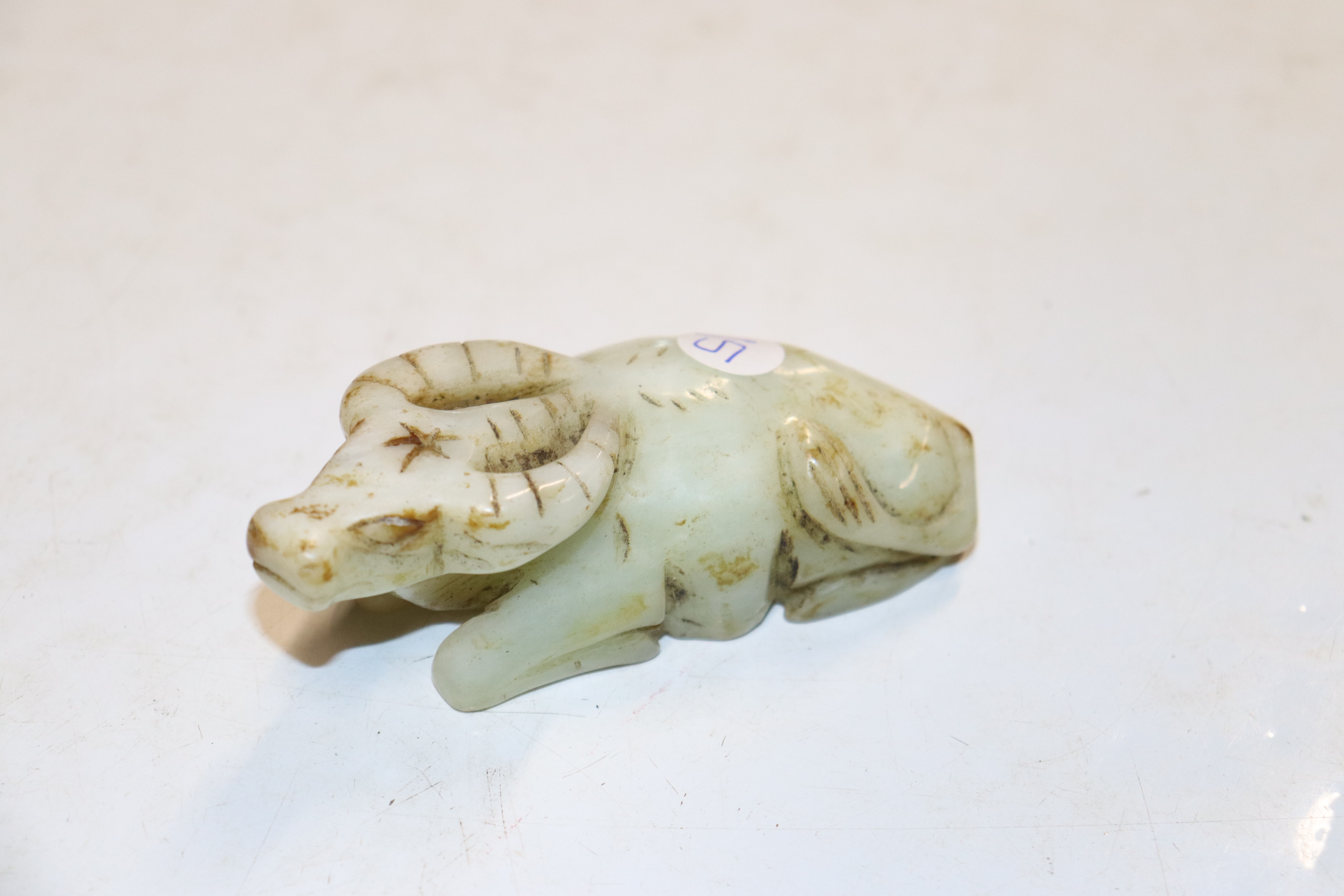 A Chinese carved pale green hardstone figure of a