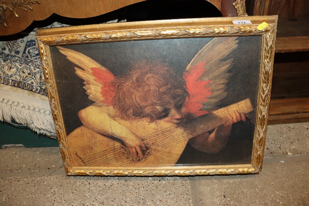 A gilt framed print depicting winged cherub playing a lute