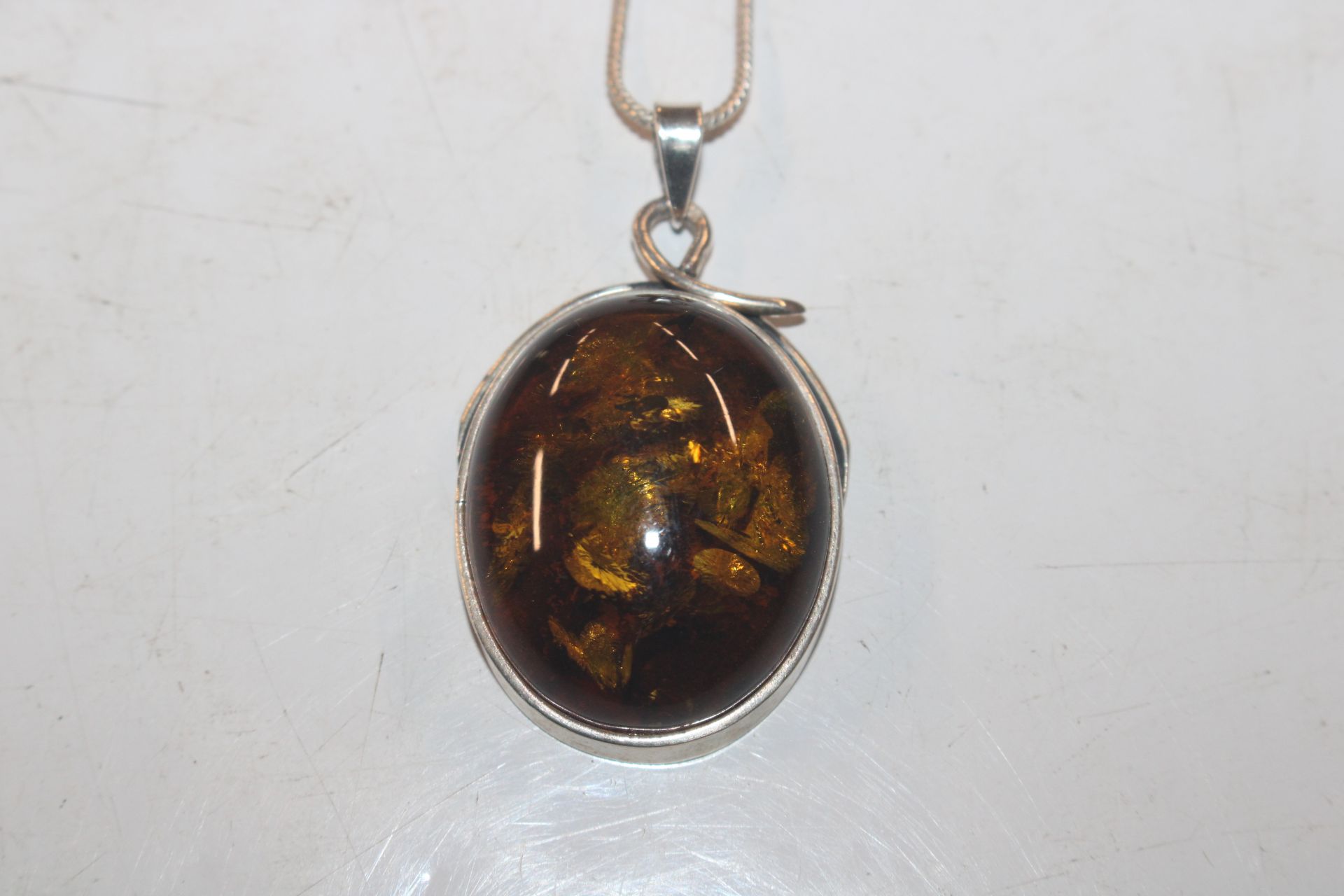A large Sterling silver and amber pendant on chain