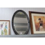 An oval framed bevel edged wall mirror