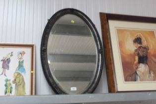 An oval framed bevel edged wall mirror