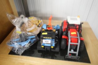 A Playmobil snow groomer and a Playmobil tractor. With various attachments etc.