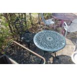 An ornate green painted circular garden table and