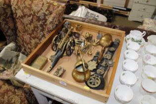 A wooden tray with contents of various brass ware