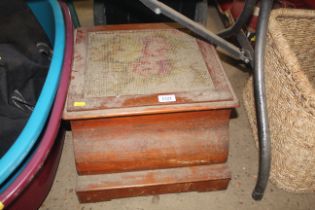 A commode enclosed within a wooden case with embro