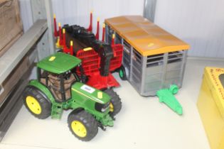 A Bruder 1/16th John Deere 6920 tractor with Bruder log trailer, logs and Bruder cattle trailer