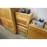 A pair of modern lightwood bedside chests each fit