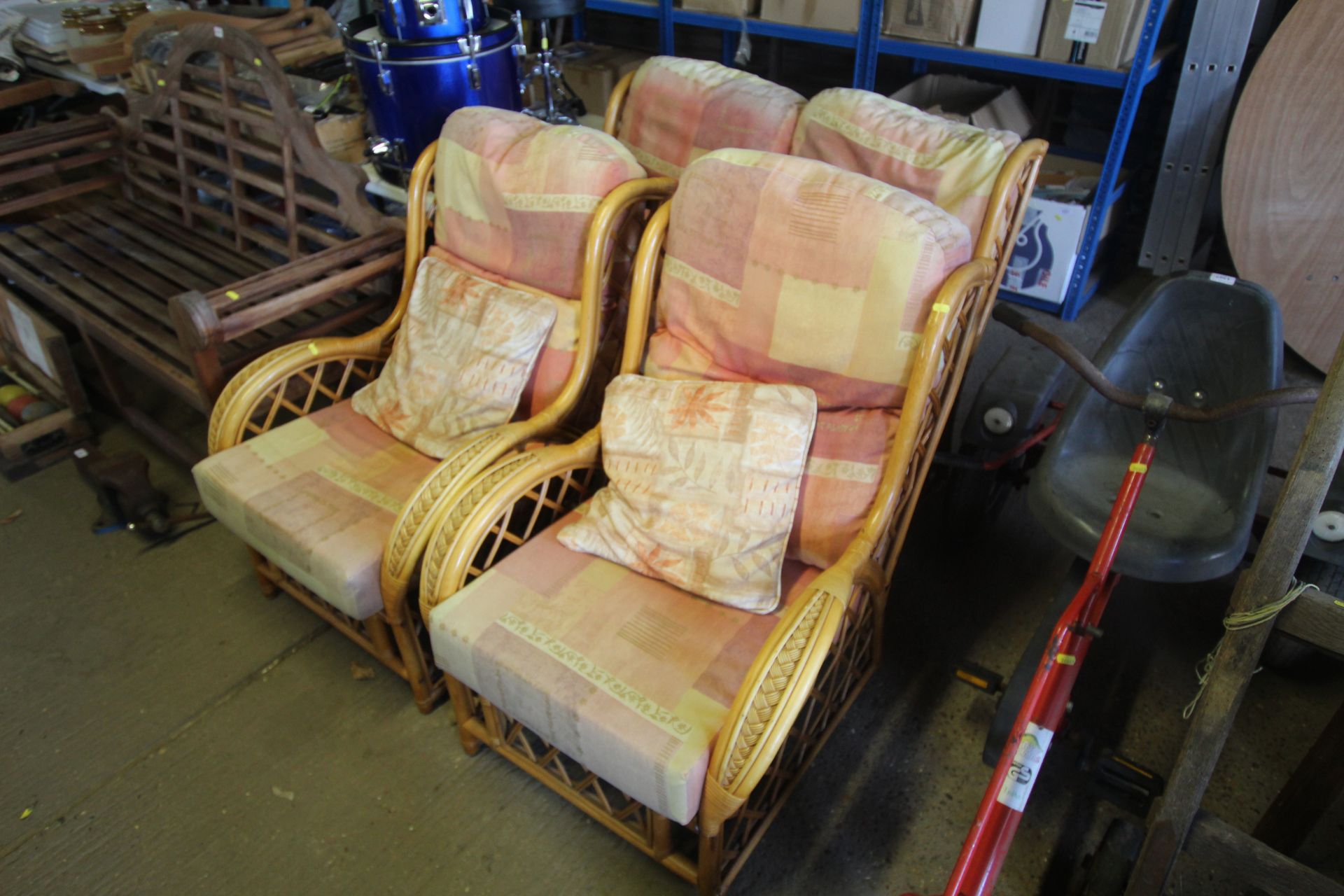 A cane three piece conservatory suite comprising two seater settee, two armchairs all with cushions