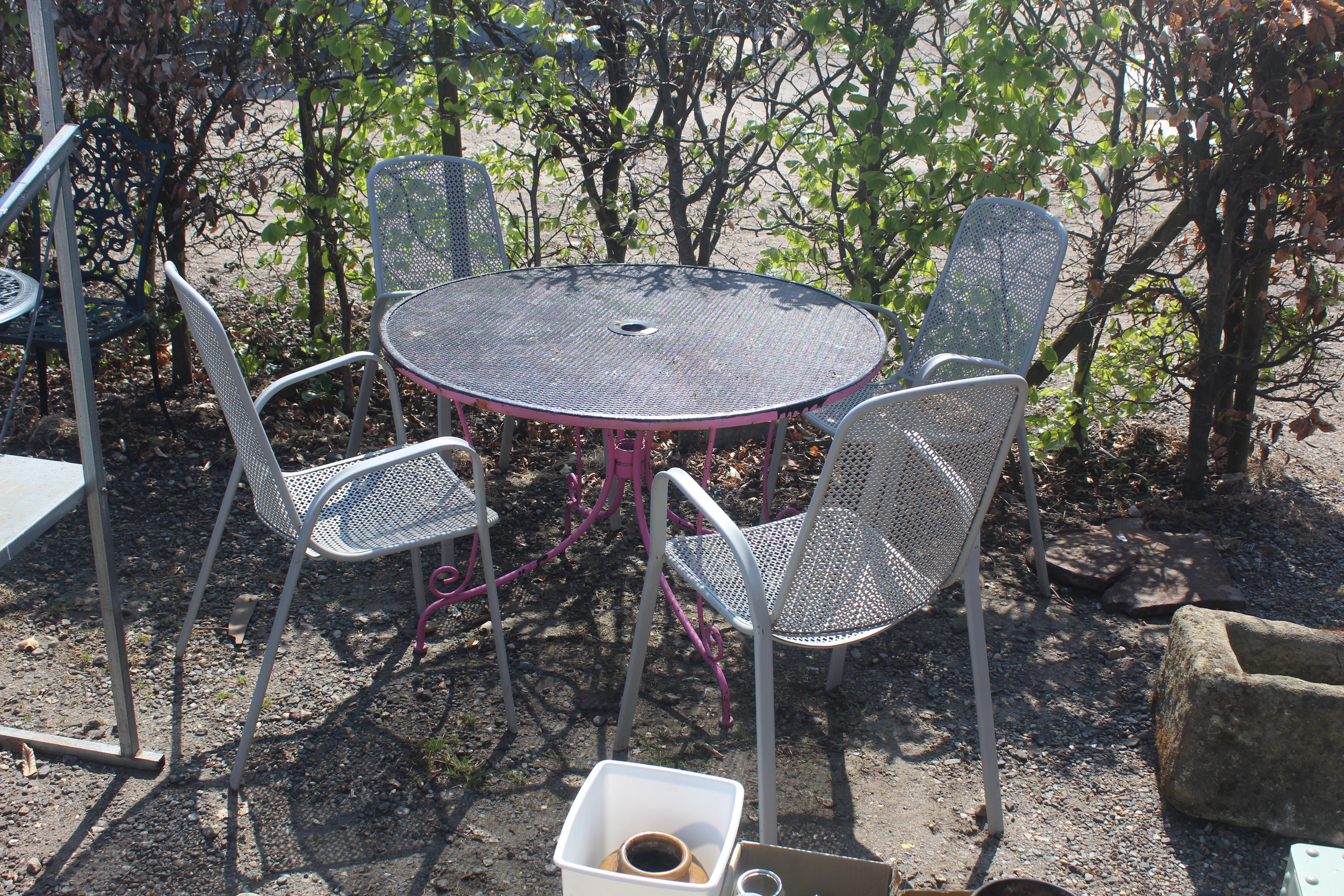A circular pierced metal garden table and set of f