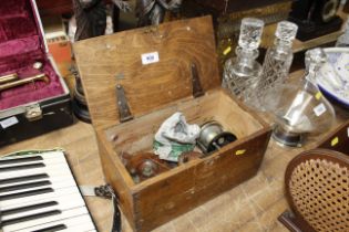 A wooden box containing a fishing reel, two vintag