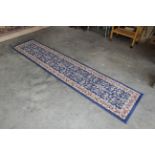 An approx. 9'11" x 2'2" blue pattern rug
