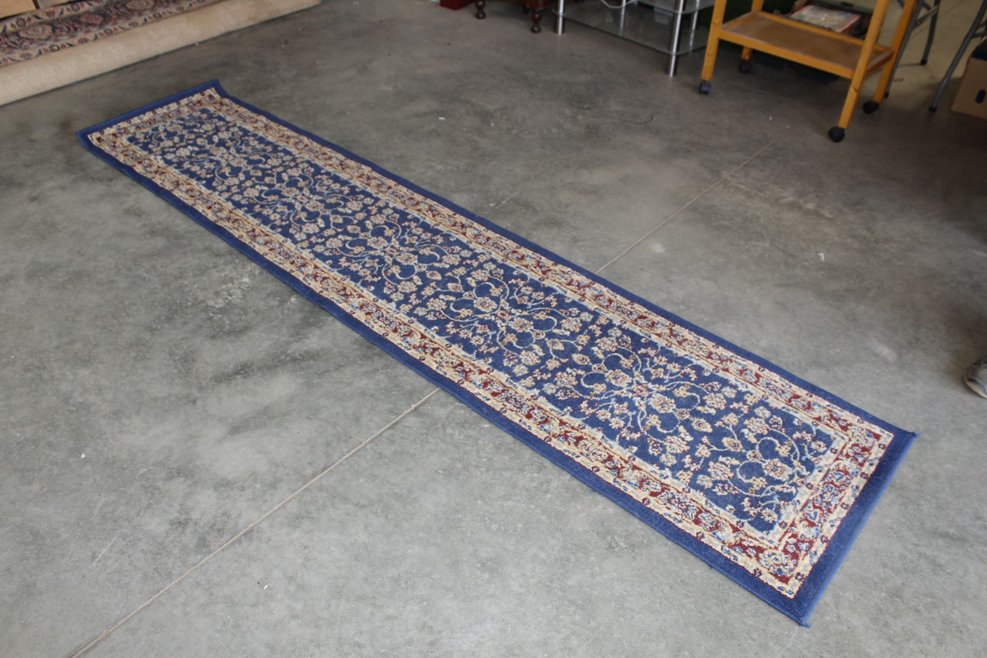 An approx. 9'11" x 2'2" blue pattern rug