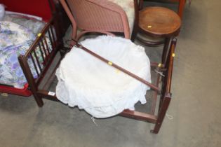 A dolls bed, wicker basket and a riding crop