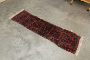 An approx. 6'8" x 1'10" red pattern runner