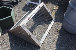 A wooden framed wire metal outdoor pet enclosure