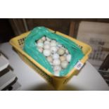 A plastic crate containing a quantity of used golf