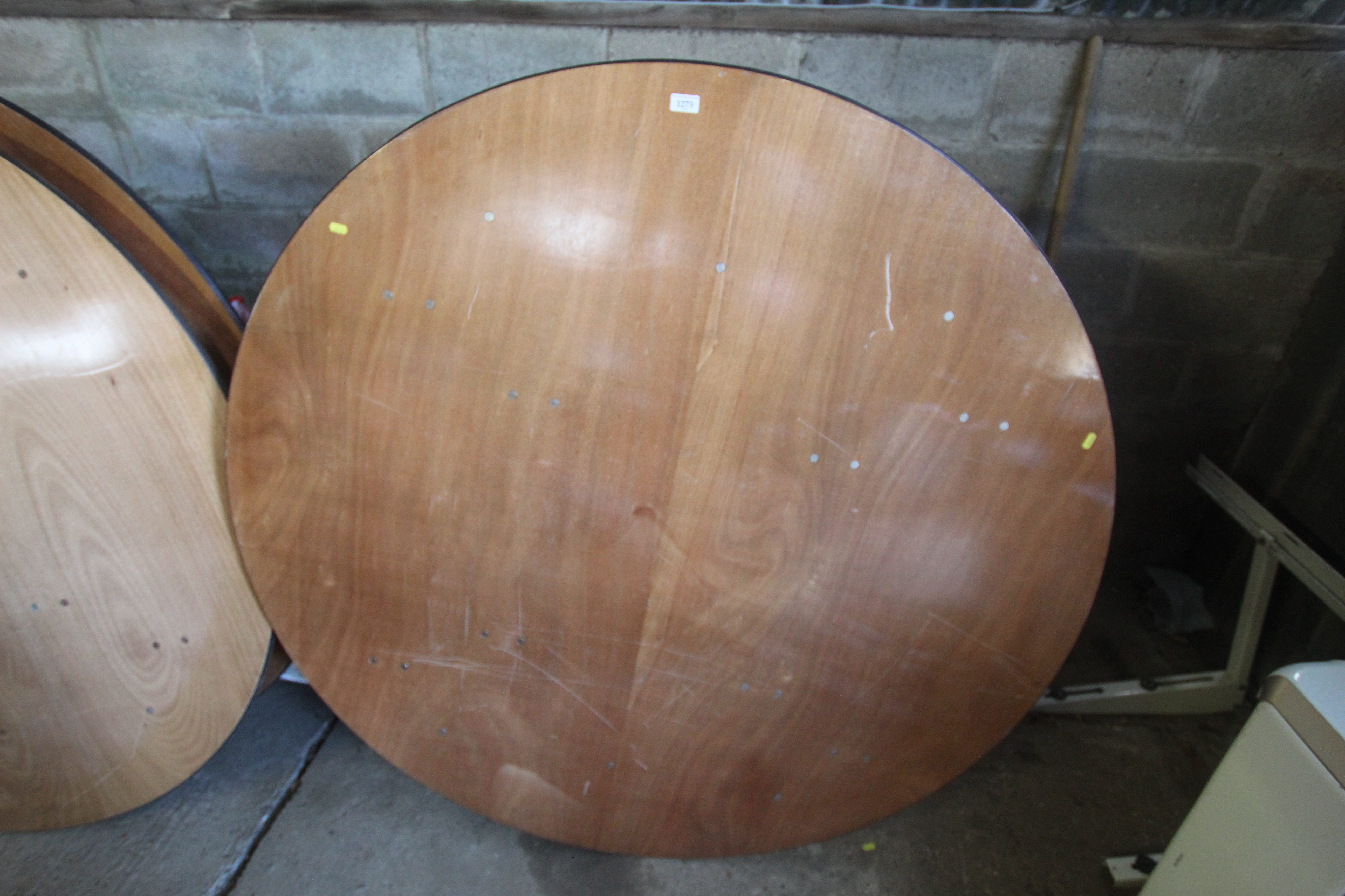 A large wooden circular folding events table appro
