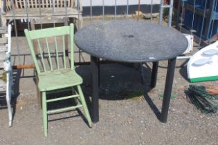 A circular garden table and a green painted stick