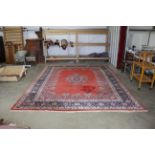 An approx. 12'9" x 9'8" red patterned rug AF