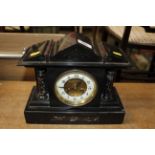 A late Victorian black slate two hole mantel clock