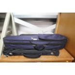 An unused suit bag and a violin case