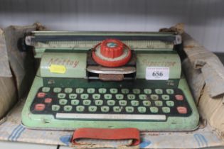 A vintage tin plate toy typewriter