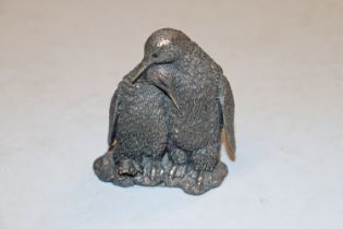 A filled silver ornament, two penguins