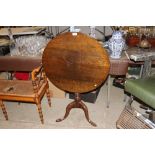 A 19th Century oak snap top table raised on tripod