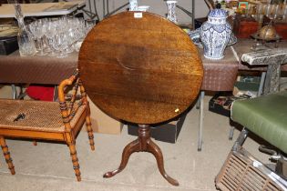 A 19th Century oak snap top table raised on tripod