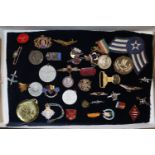 A tray containing assorted badges to include milit