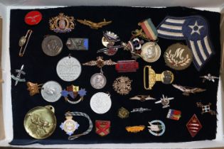 A tray containing assorted badges to include milit